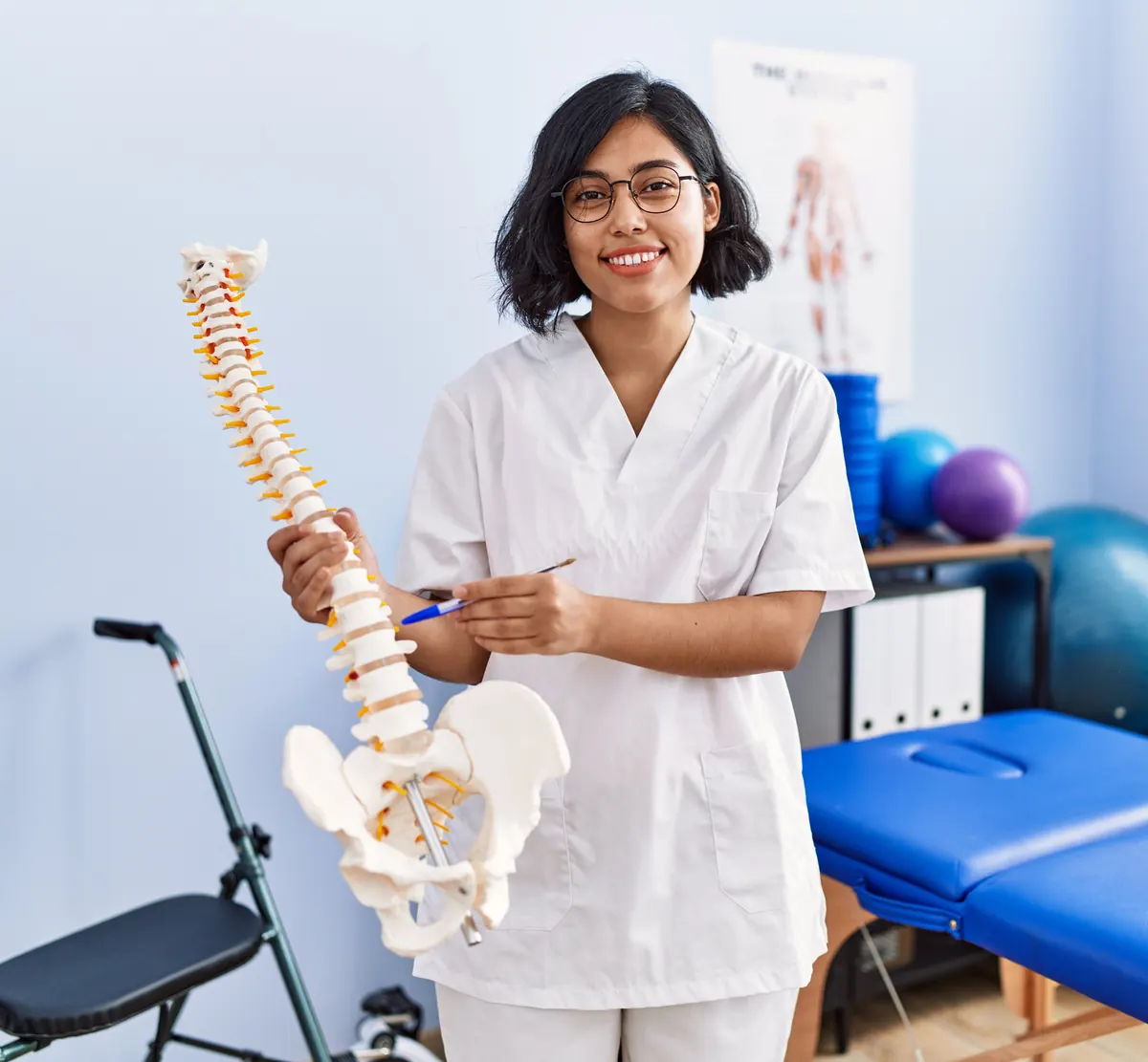 Fisioterapeuta sorrindo com modelo de coluna